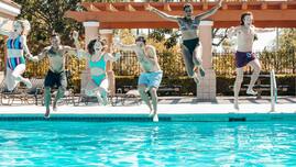 five friends in mid air jumping into a swimming pool in Milton, Ontario